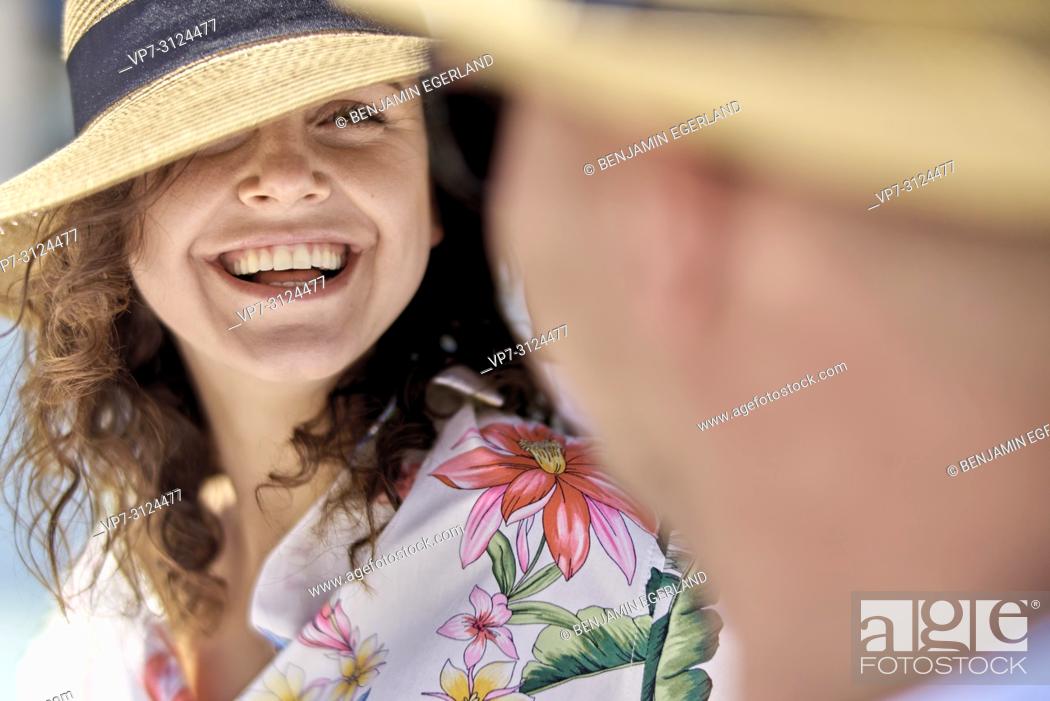 Imagen: woman next to man, sunhat, vacations, happiness, toothy smile.