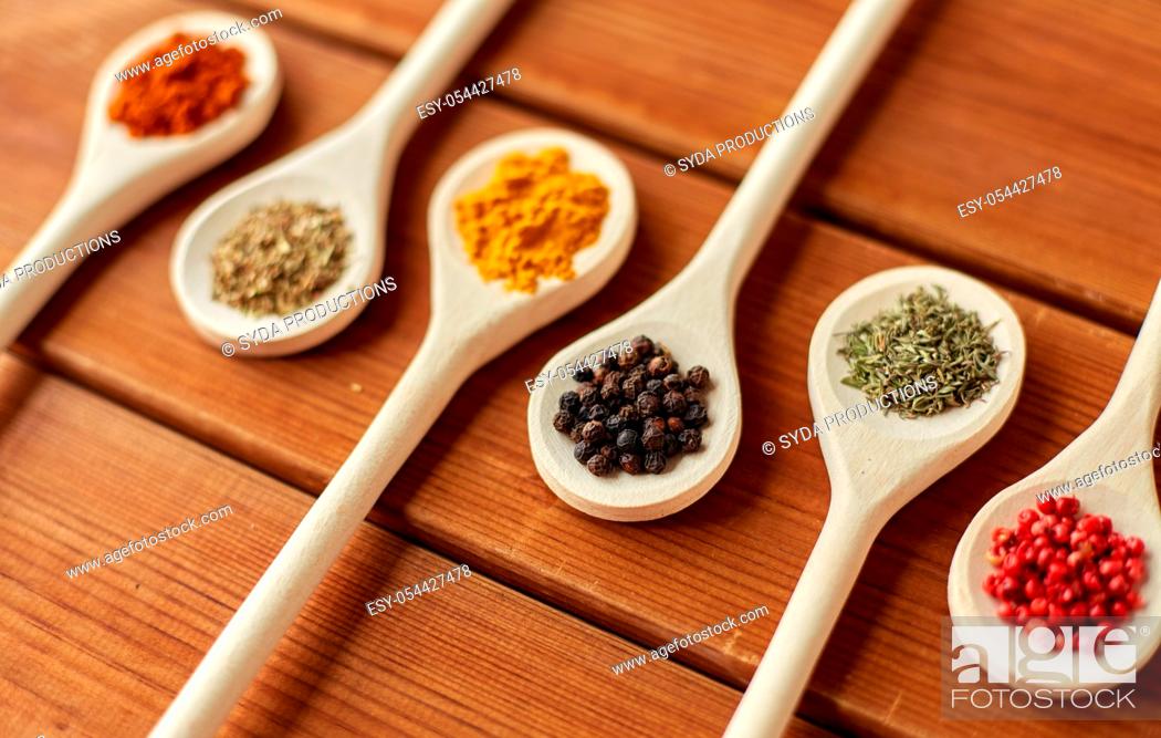 Stock Photo: spoons with different spices on wooden table.