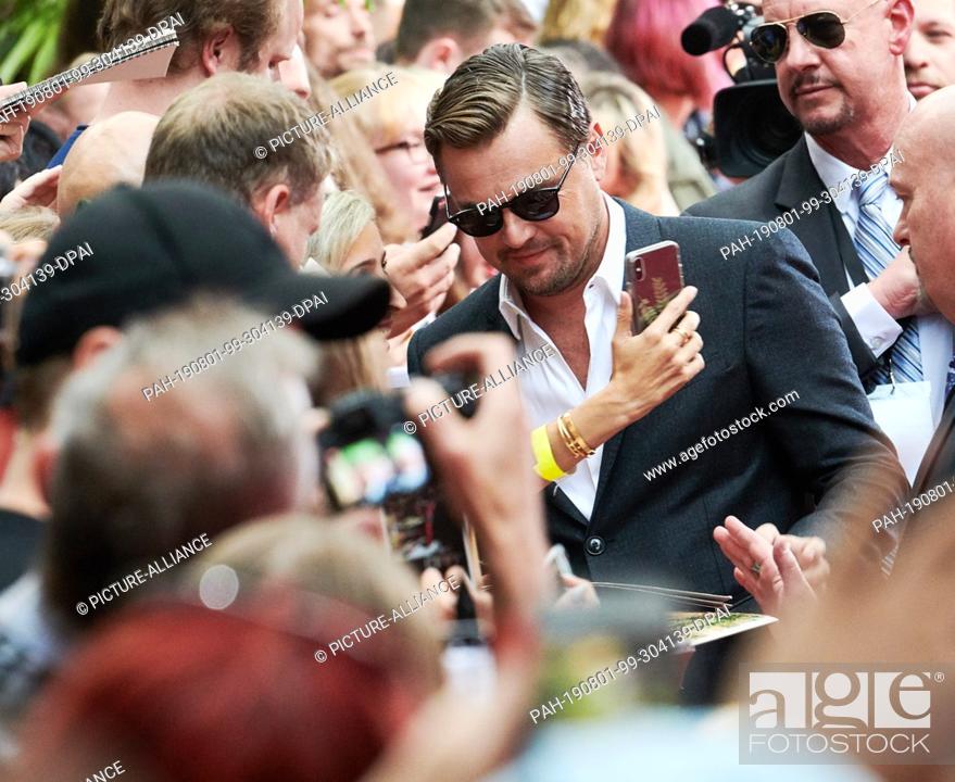 Stock Photo: 01 August 2019, Berlin: US actor Leonardo DiCaprio comes to the premiere of his film ""Once upon a time...in Hollywood"" and gives autographs to his fans.