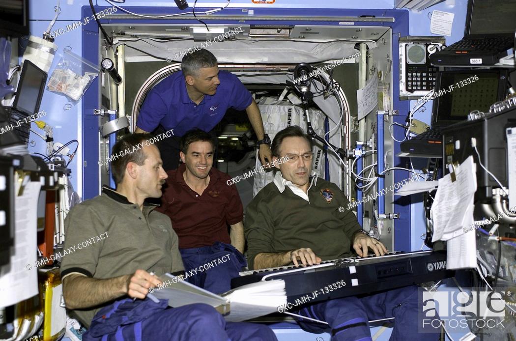 Stock Photo: Astronaut Carl E. Walz (right), Expedition Four flight engineer, plays host to some crewmates as he performs on a musical keyboard in the Destiny laboratory on.