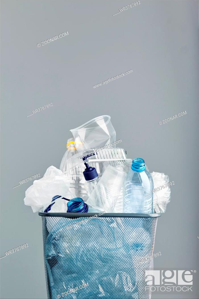 Stock Photo: Heap of plastic bottles, cups, bags collected to recycling in a metal bin. Concept of plastic pollution and too many plastic waste.