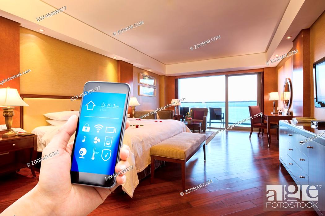 Stock Photo: mobile phone with smart home app in modern bed room.