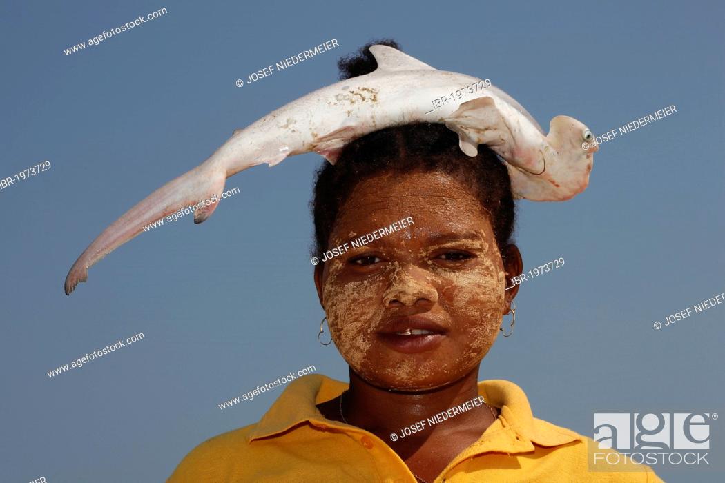 Stock Photo: Fishwife carrying a small hammerhead shark on her head, Morondava, Madagascar, Africa, Indian Ocean.