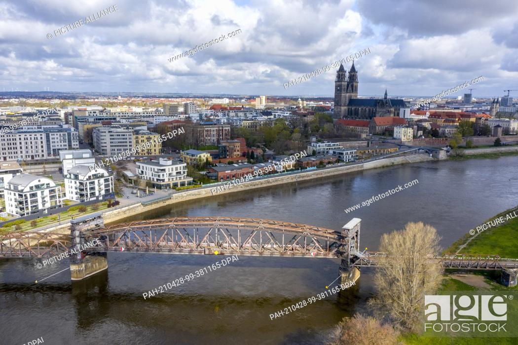 Stock Photo: 24 April 2021, Saxony-Anhalt, Magdeburg: View of the city centre of Magdeburg with the lift bridge, the cathedral and modern residential buildings near the.