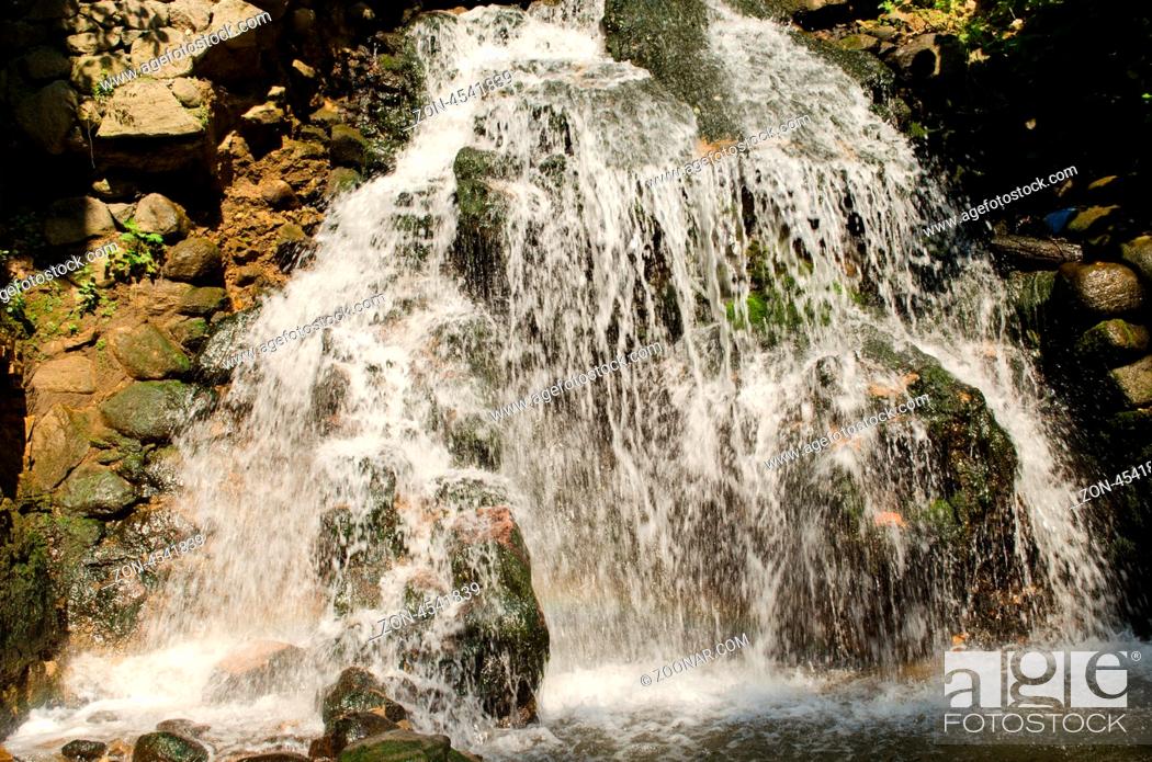 Stock Photo: powerful waterfall on rocky slopes in summer.