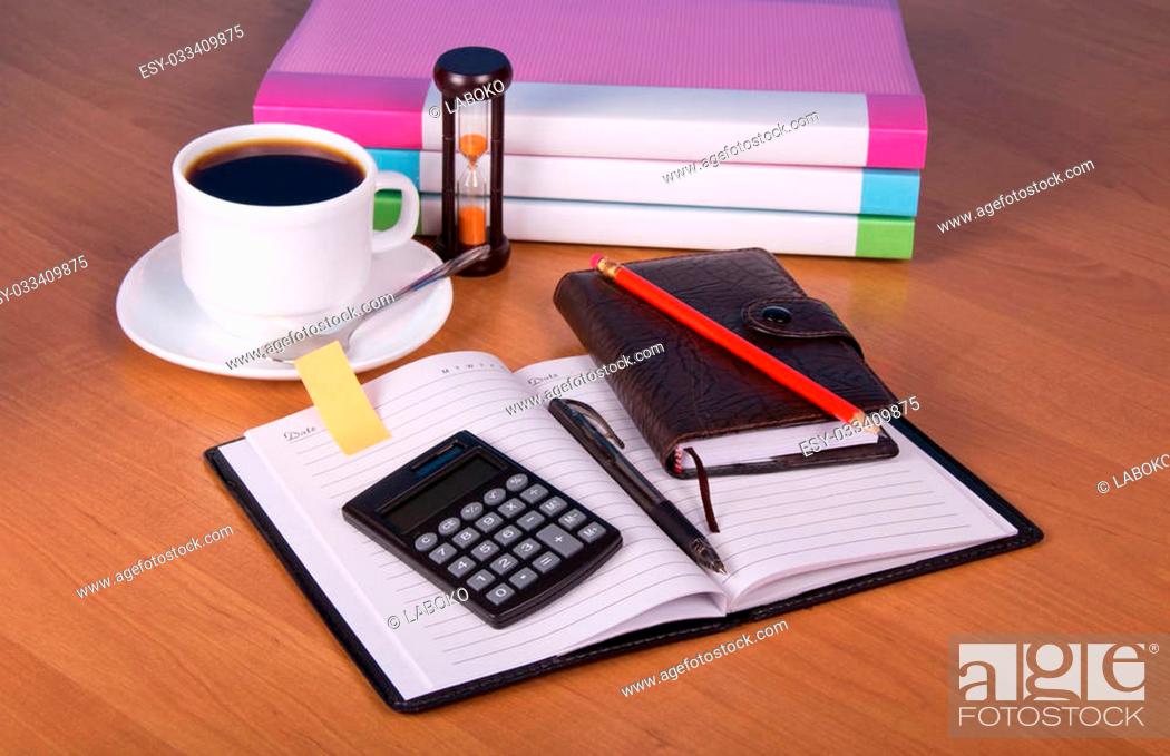 Stock Photo: Notepad, organizer, folders for documents the calculator, hourglasses and a cup of coffee on a table.