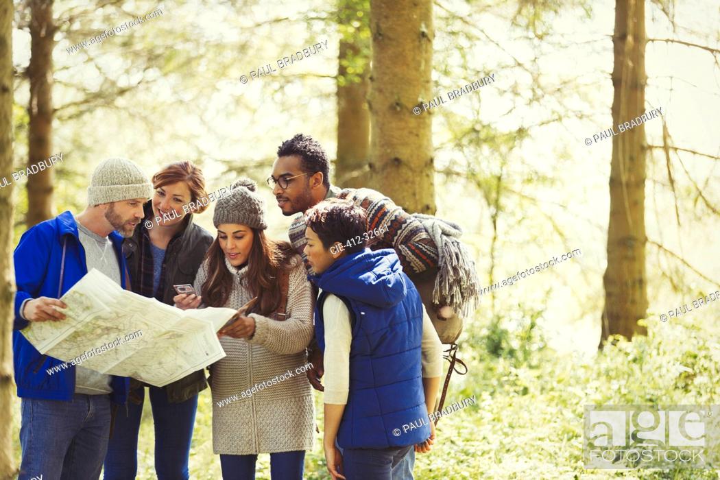 Stock Photo: Friends with map hiking in woods.