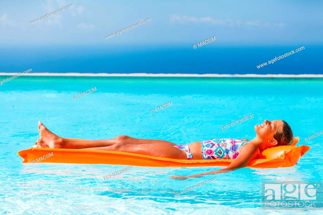 Stock Photo: Adorable girl relaxing at the swimming pool.