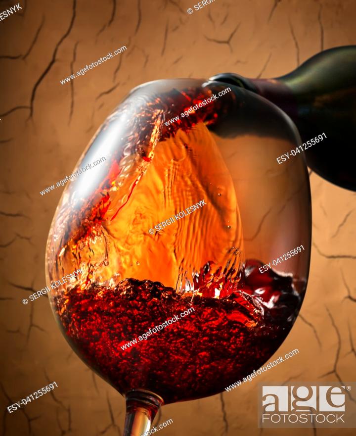 Photo de stock: Red wine pouring into wineglass on clay background.