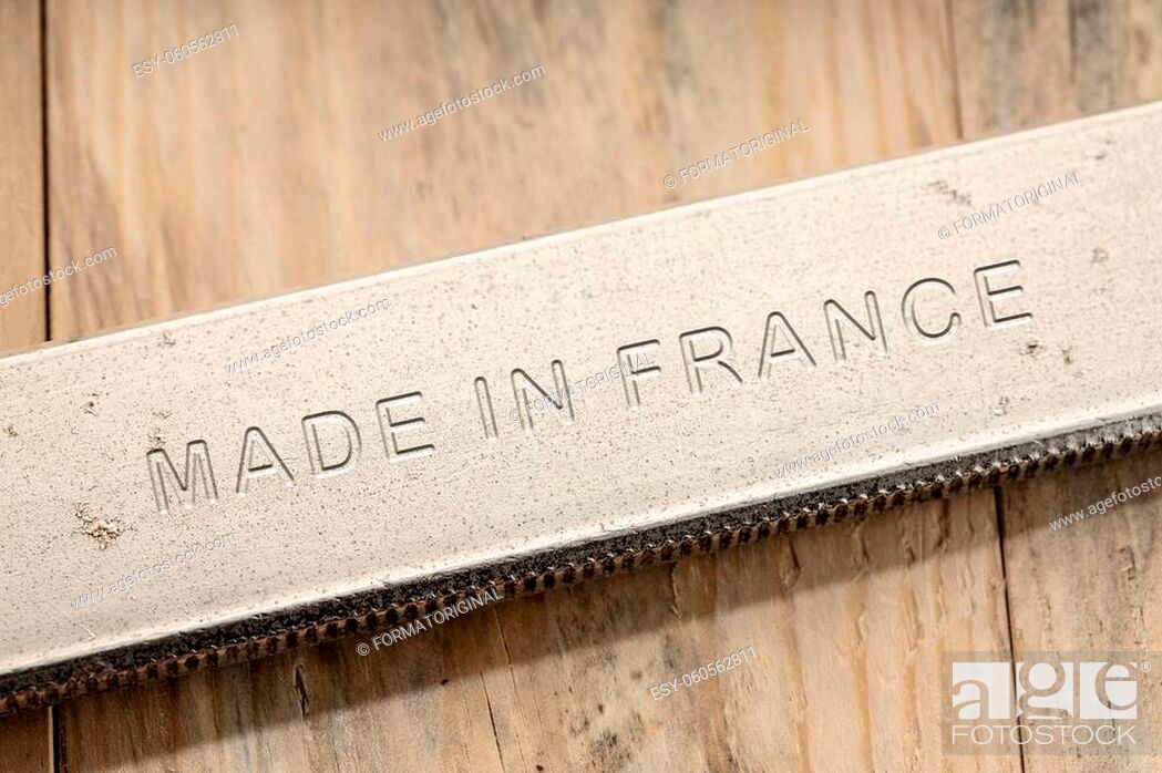 Stock Photo: Made in France engraved on steel tool on wooden table. Close up.