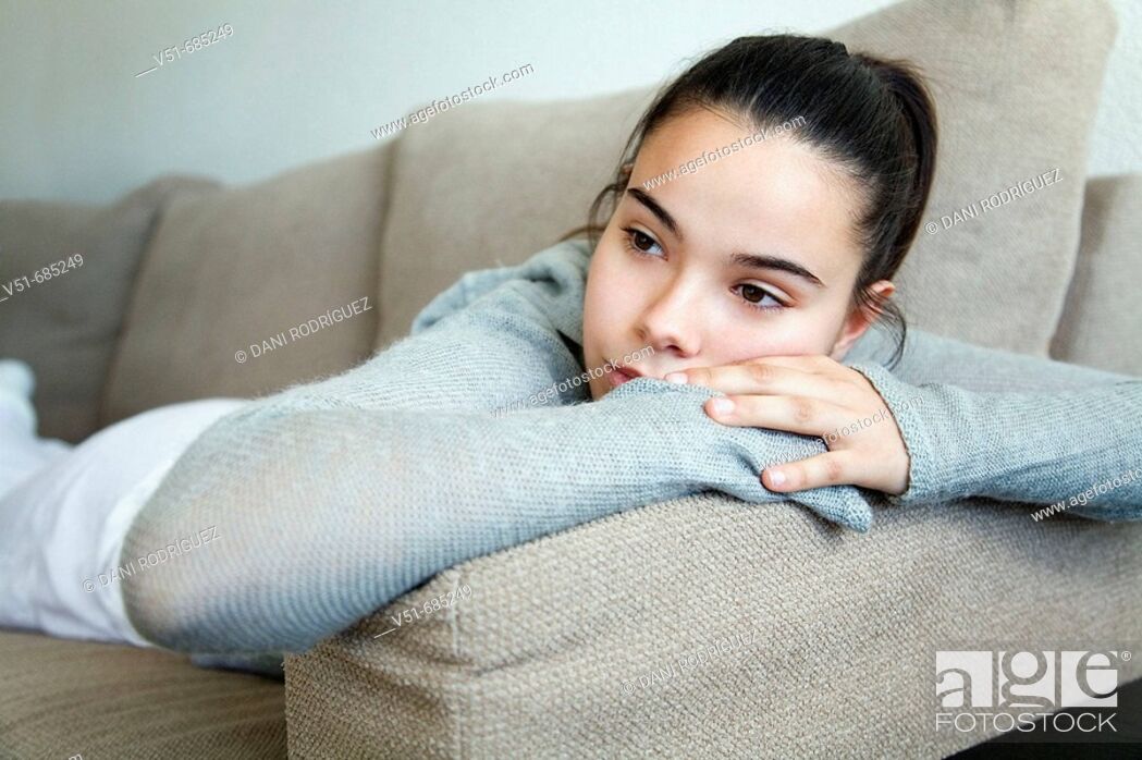Stock Photo: Teenage girl lying on the couch daydreaming.