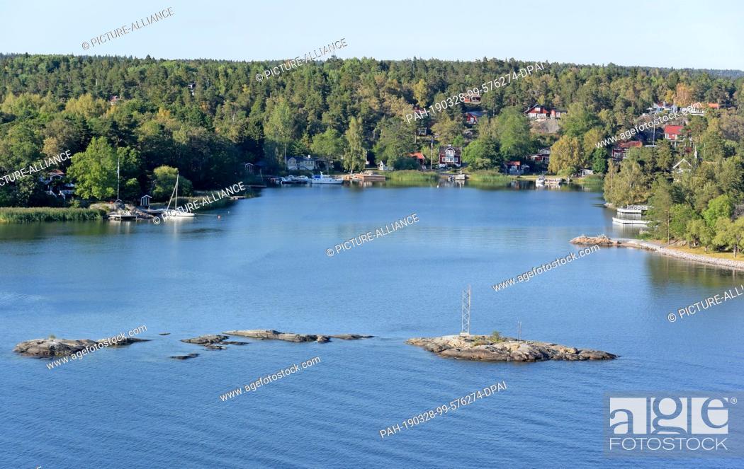 Stock Photo: 13 July 2018, Sweden, Stockholm: Archipelago with houses and jetties near the Swedish capital. The Stockholm Archipelago consists of about 30, 000 islands.