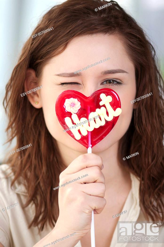 Stock Photo: Portrait of pretty woman with candy heart. Love.