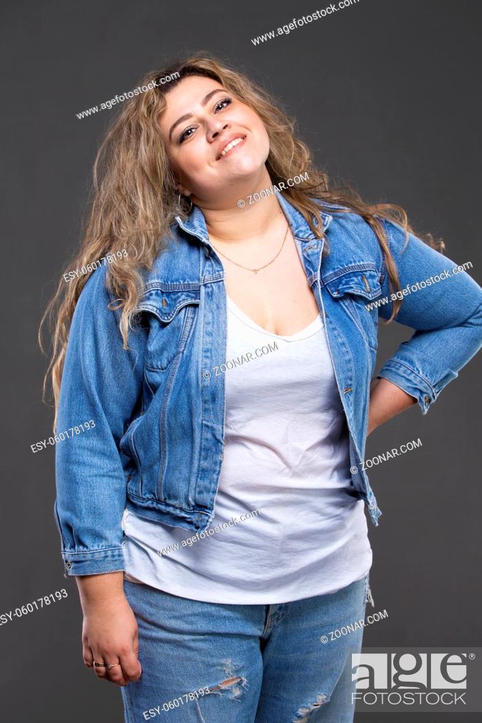 Zeg opzij Tenen Martelaar A beautiful fat woman in a denim jacket looks at the camera and smiles on a  gray background, Stock Photo, Picture And Low Budget Royalty Free Image.  Pic. ESY-060178193 | agefotostock