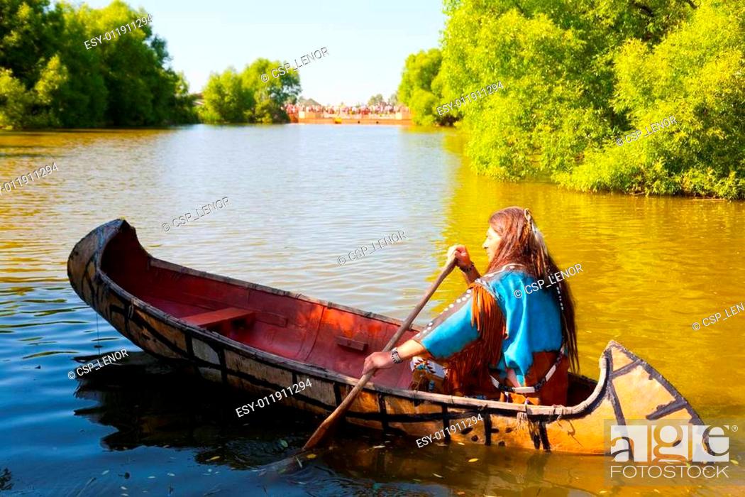 Stock Photo: North American Indian floats down the river on a canoe.