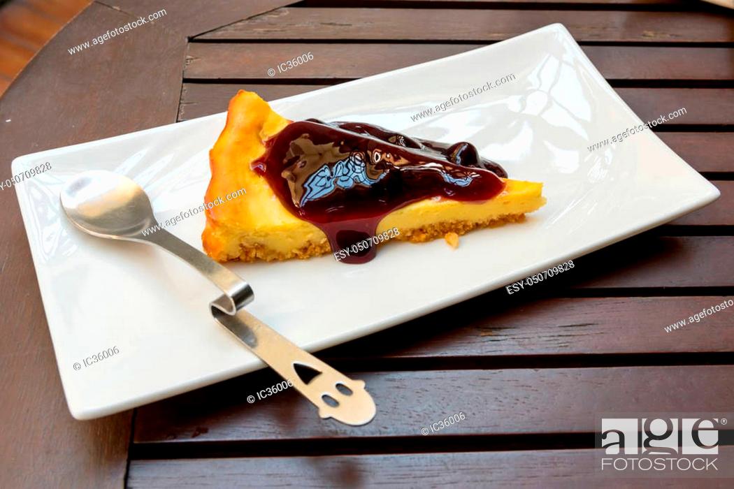 Stock Photo: Blueberry Cheesecake with little spoon on a plate.