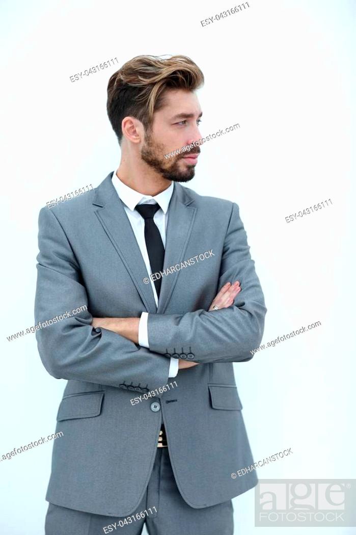 Stock Photo: Portrait of a young man standing with arms crossed and looking away. Isolated on white background.