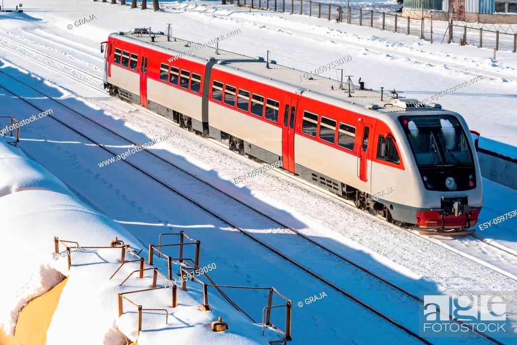 Stock Photo: A short passenger train on railway track in a snow.