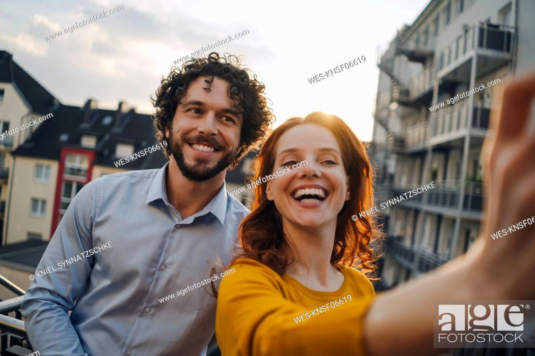 Stock Photo: Two happy colleagues on roof terrace taking a selfie.