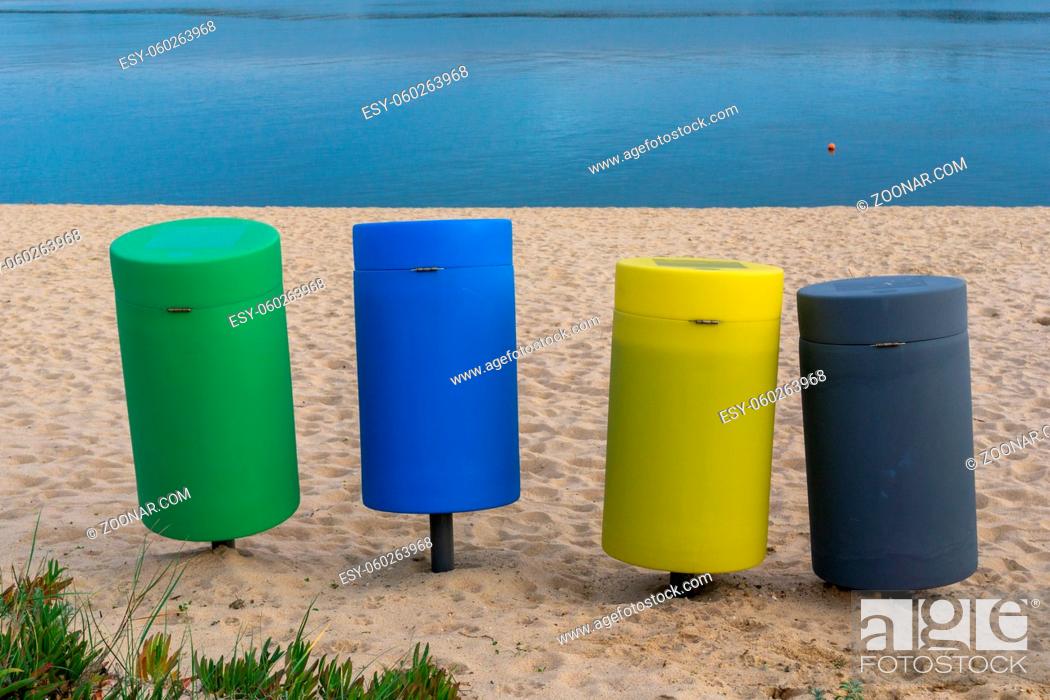 Stock Photo: Four colorful recycling bins on a sandy beach.
