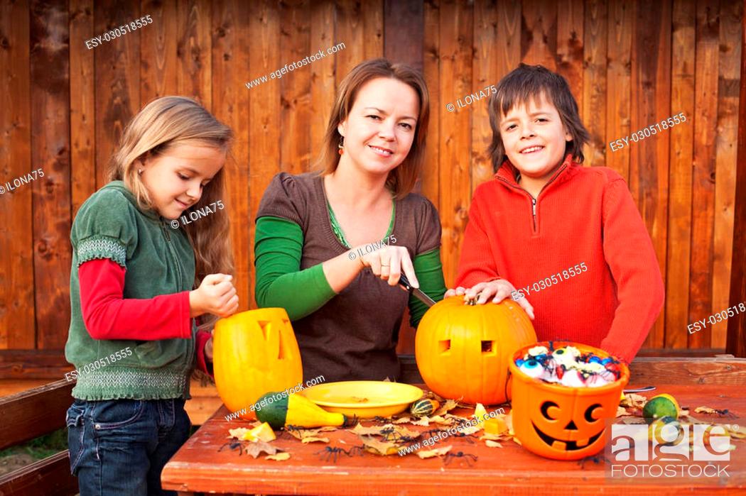 Stock Photo: Family carving pumpkin lanterns for halloween - preparing the spooky accessories.
