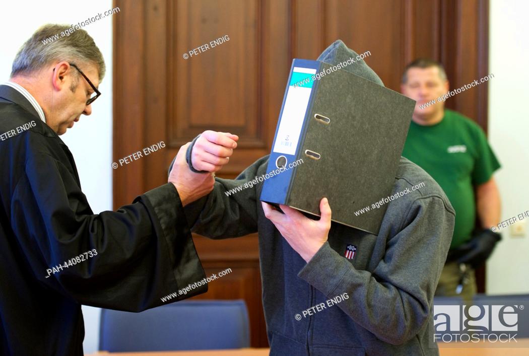Stock Photo: The defendant Jan Julius N. covers his face before the verdict in the Land court in Leipzig, Germany, 15 November 2013. In May 2013 the 34 year old attacked a.