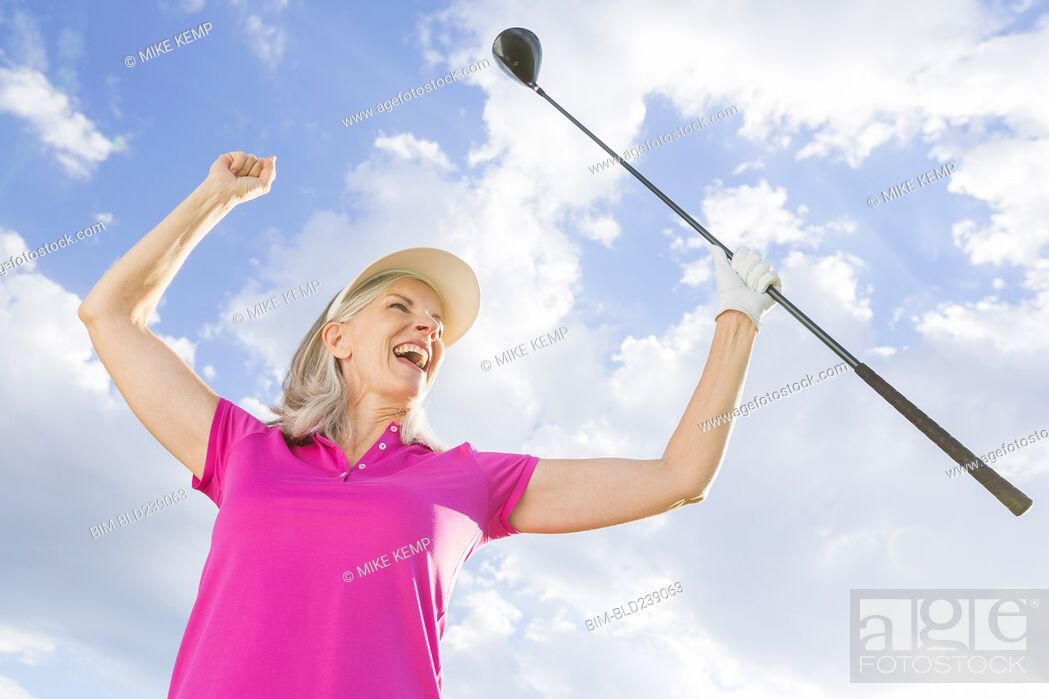 Stock Photo: Caucasian woman celebrating with golf club.