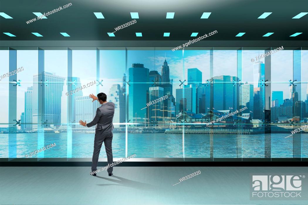 Stock Photo: Businessman in front of office window thinking of new challenges.