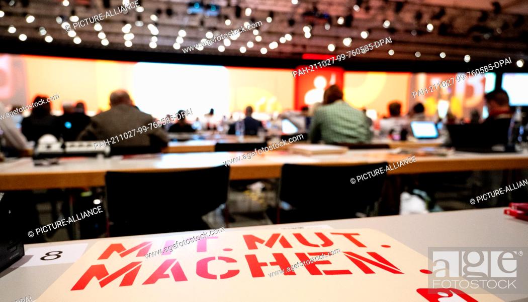 Stock Photo: 27 October 2021, Lower Saxony, Hanover: A sign with the inscription ""Mit.Mut.Machen"" lies on a table at the 7th Ordinary Trade Union Congress of the Mining.
