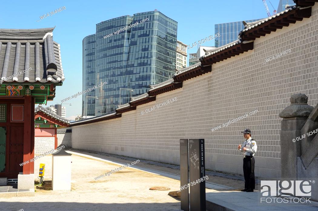 Stock Photo: Seoul, South Korea, Asia - A uniformed security guard stands besides the Gwanghwamun gate at the Gyeongbokgung Palace, the largest of the Five Grand Palaces.