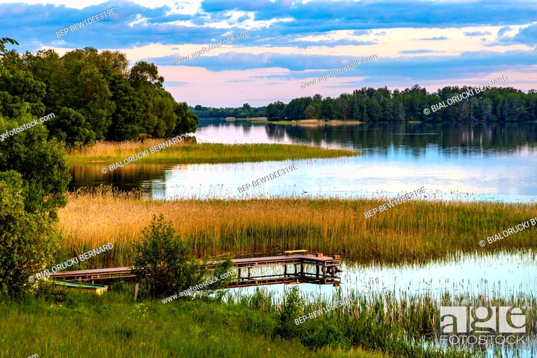 Stock Photo: Panoramic summer view of Jezioro Selmet Wielki lake landscape with vintage pier reeds and wooded shoreline in Sedki village in Masuria region of Poland.
