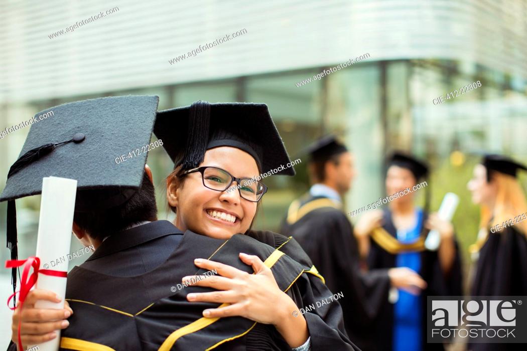 Stock Photo: Students in cap and gown hugging.