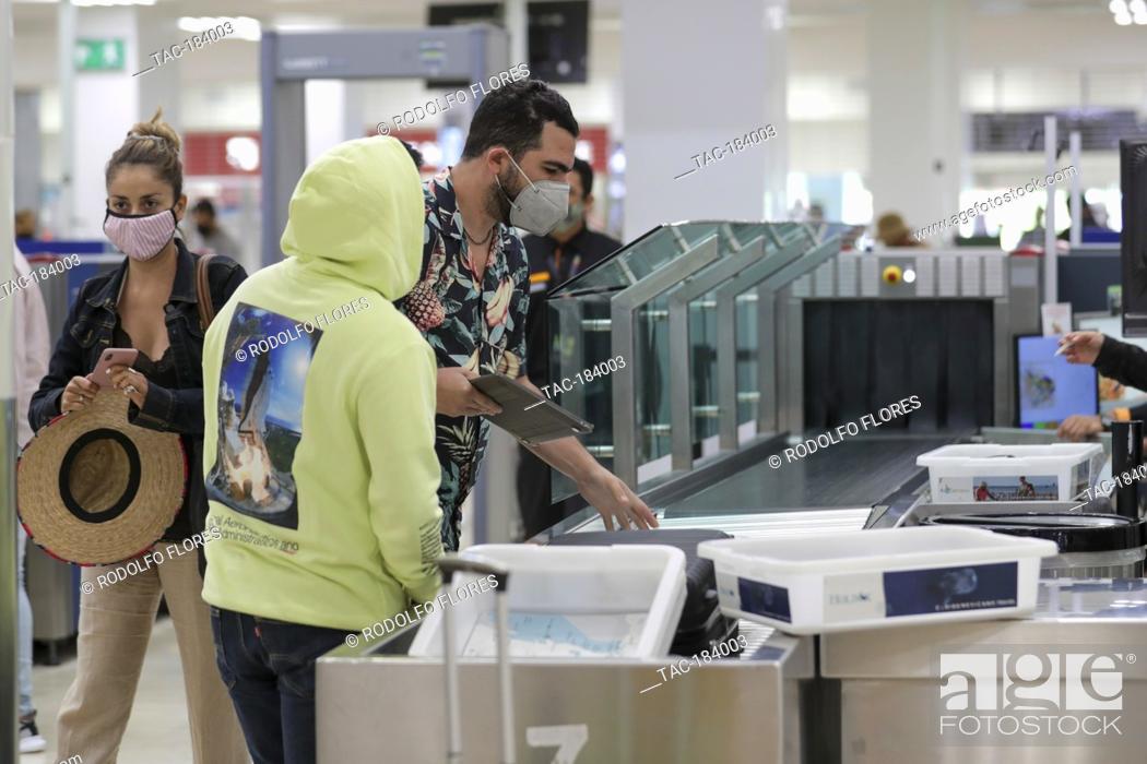 Stock Photo: CANCUN, MEXICO - NOVEMBER 19: A person wears protective mask during the baggage check before board the plane at Cancun International Airport on November 19.