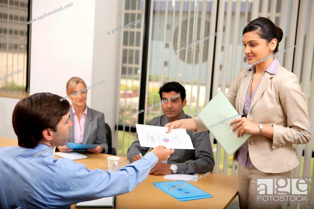 Stock Photo: Female executive handing over a document.
