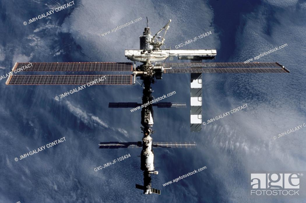 Stock Photo: Backdropped by a dark blue and white Earth, this full view of the International Space Station (ISS) was photographed by a crewmember on board the Space Shuttle.