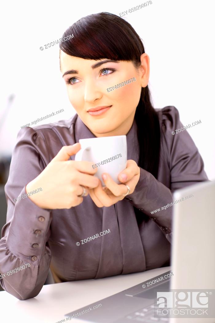 Stock Photo: Young businesswoman daydreaming over her coffe in the office.