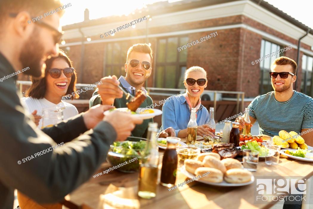 Stock Photo: friends having dinner or bbq party on rooftop.