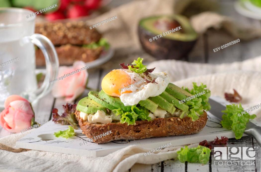 Stock Photo: Homemade avocado poached egg sandwich wholegrain bread, food photography.
