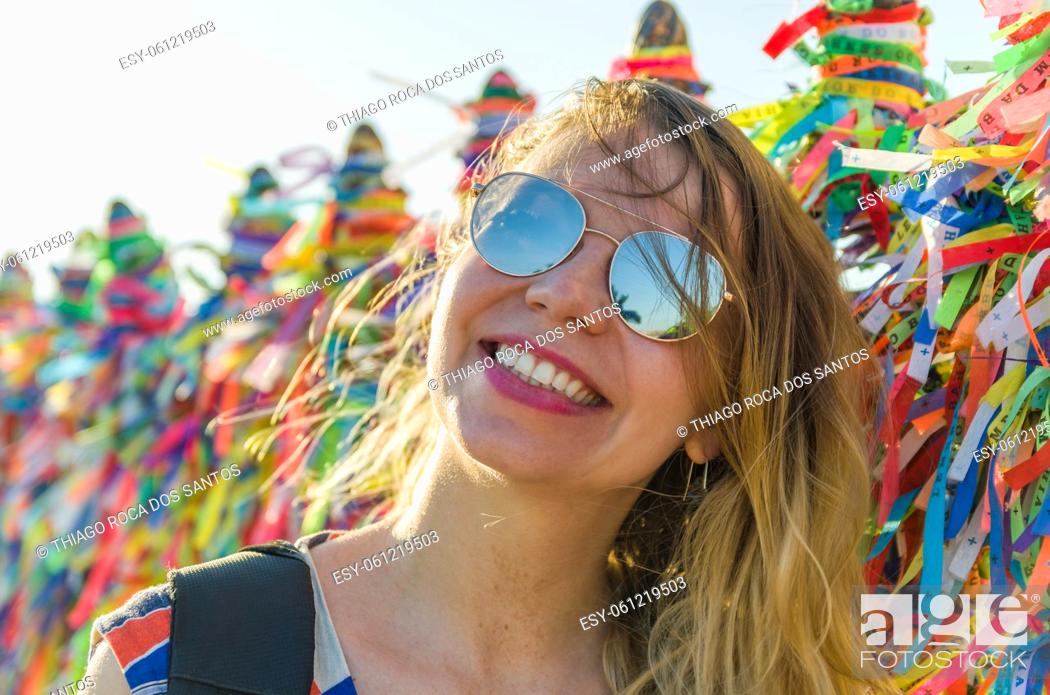 Stock Photo: Girl in front of the grid with colored ribbons of Bonfim church in Salvador Bahia Brazil.
