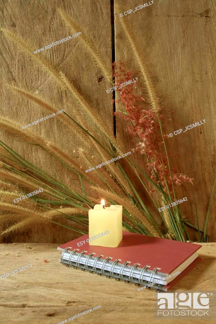 Stock Photo: Still life notebook and candle light with foxtail grass on grunge wooden background, vintage style.