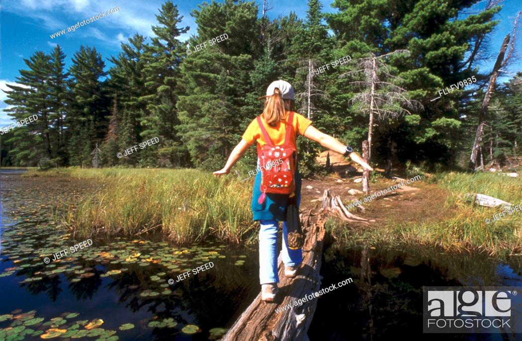 Stock Photo: Girl Walking on Log over Water, Algonquin Park, Ontario.