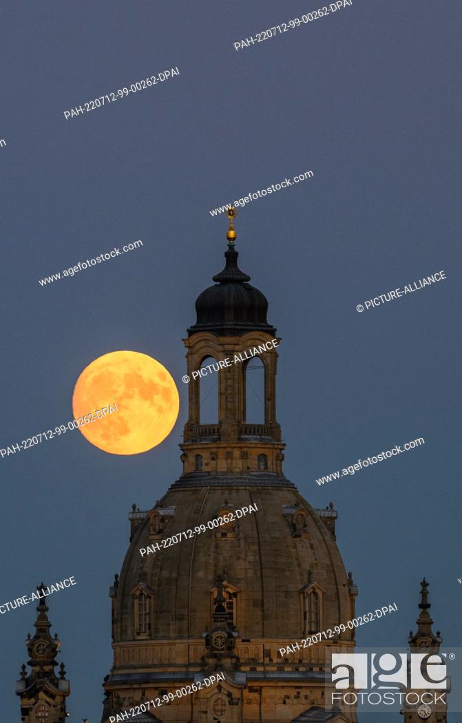 Stock Photo: 12 July 2022, Saxony, Dresden: The waxing moon rises in the evening behind the Frauenkirche. On July 13, 2022, the moon will be full shortly after 8:30 pm.