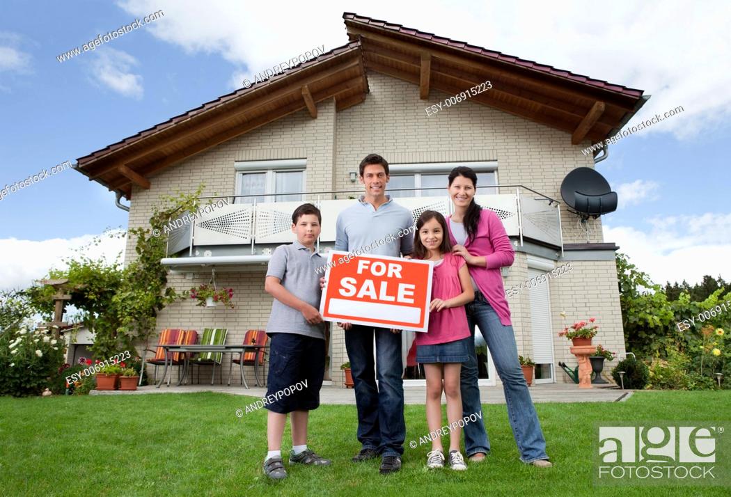 Stock Photo: Portrait of young family selling their home holding for sale sign.