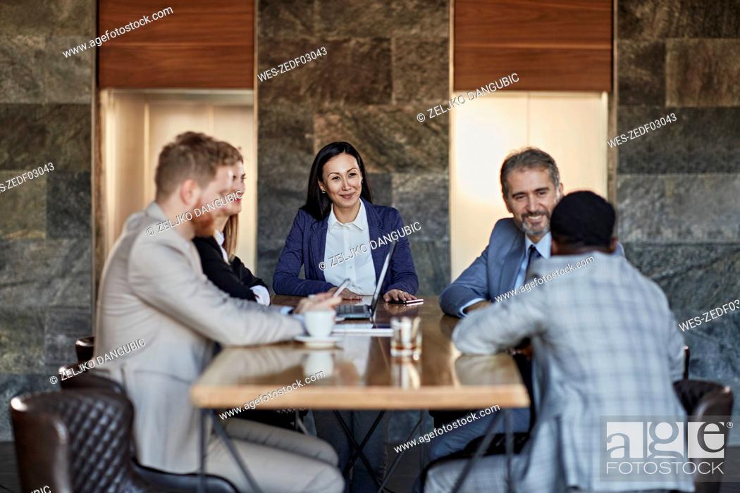 Imagen: Business people having a meeting in hotel lobby.