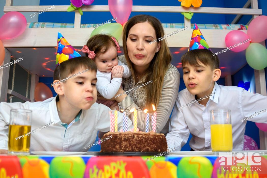 Stock Photo: Family blowing candles on birthday cake.