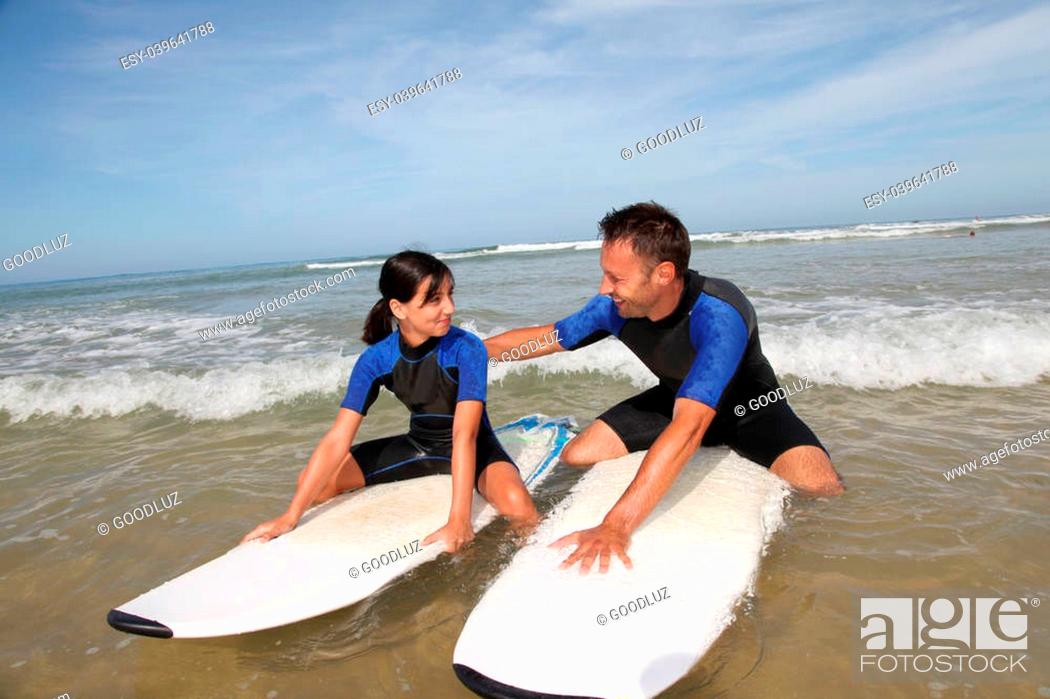 Stock Photo: Father and daughter surfing in the ocean.