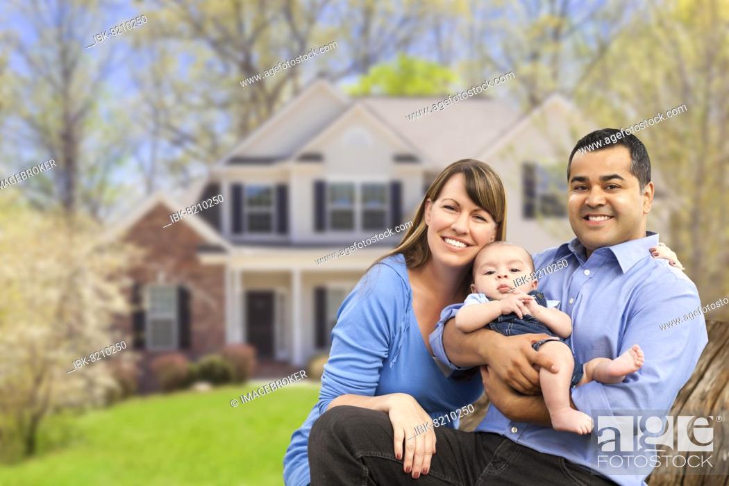 Stock Photo: Happy mixed-race couple in front of beautiful house.