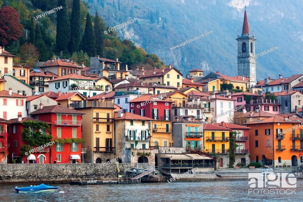 Stock Photo: View over lake of town of Varenna along lake shore with mountain range beyond on calm autumn afternoon in pale sunlight, Lake Como, Northern Italy.