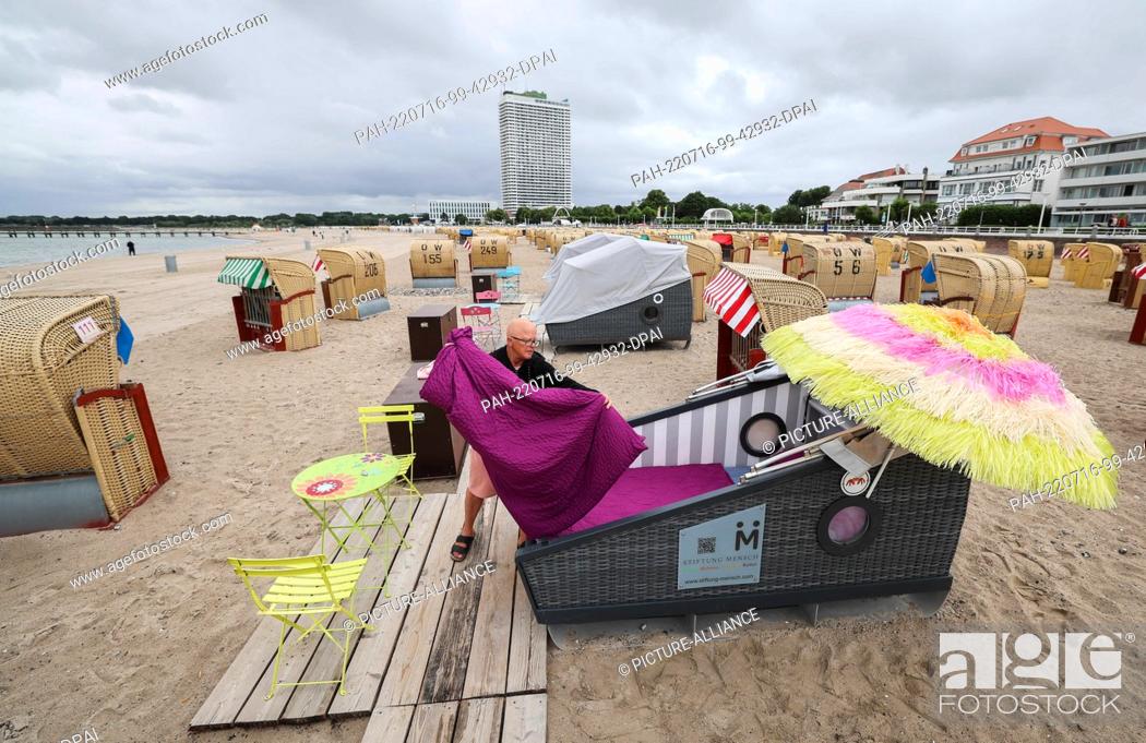 Stock Photo: 07 July 2022, Schleswig-Holstein, Travemünde: Regina Nordmann, a family member of the Seipel beach chair rental company, prepares a sleeping beach chair for the.