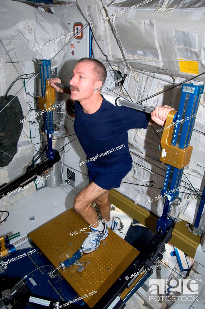 Stock Photo: NASA astronaut Dan Burbank, Expedition 30 flight commander, exercises, using the advanced Resistive Exercise Device (aRED) in the Tranquility node of the.